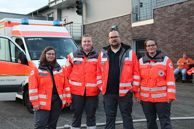 Helfende des Sanitätsdienstes vor einem Rettungswagen