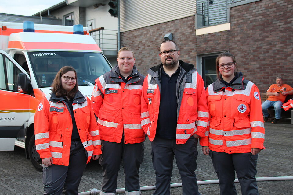 Helfende des Sanitätsdienstes vor einem Rettungswagen