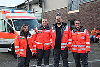 Helfende des Sanitätsdienstes vor einem Rettungswagen